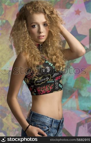 fashion portrait of beautiful teenager girl with long curly blonde hair, sexy top and casual short. Natural fresh expression.