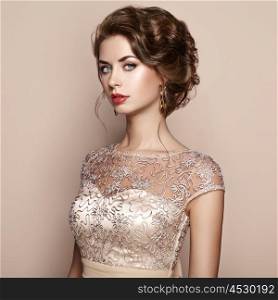 Fashion portrait of beautiful woman in elegant dress. Girl with elegant hairstyle and jewelry