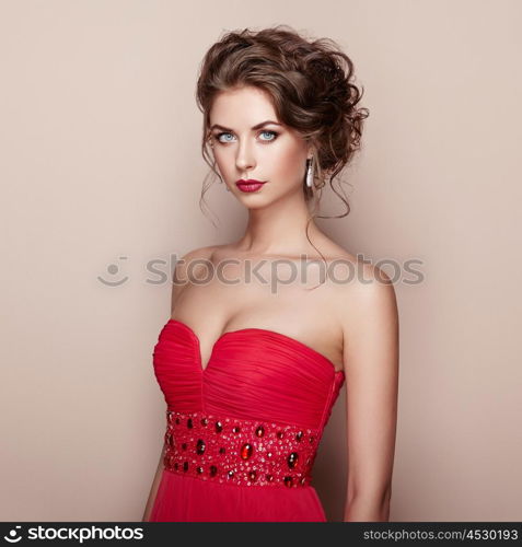 Fashion portrait of beautiful woman in elegant dress. Girl with elegant hairstyle and jewelry