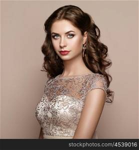 Fashion portrait of beautiful woman in elegant dress. Girl with elegant hairstyle and jewelry
