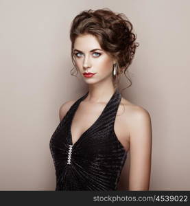 Fashion portrait of beautiful woman in elegant dress. Girl with elegant hairstyle and jewelry