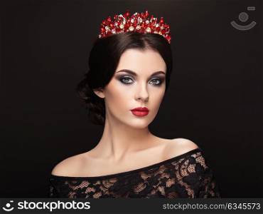 Fashion Portrait of Beautiful Woman with Tiara on head. Elegant Hairstyle. Perfect Make-Up and Jewelry. Red Lips