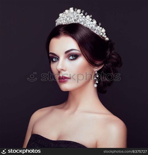 Fashion Portrait of Beautiful Woman with Tiara on head. Elegant Hairstyle. Perfect Make-Up and Jewelry. Red Lips