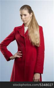 fashion portrait of beautiful woman with winter clothes. She wearing red coat, posing with natural make-up and long blonde hair