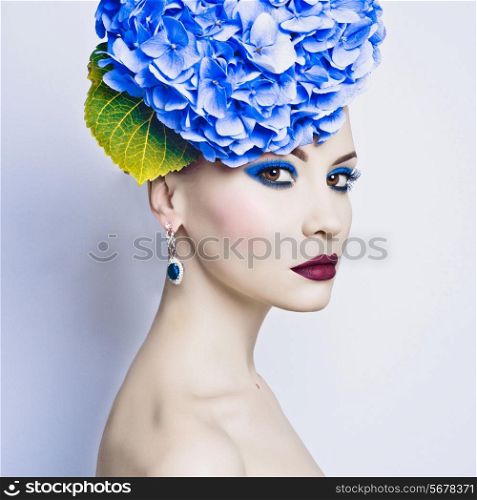 Fashion portrait of beautiful young lady with blue hydrangea