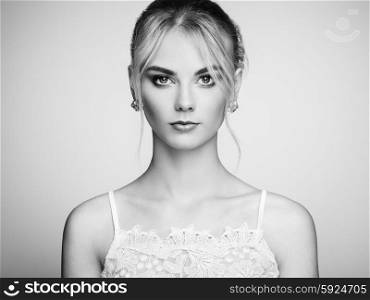 Fashion portrait of beautiful young woman with blond hair. Girl in white dress on white background