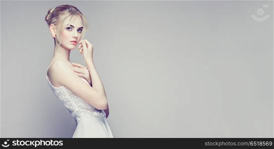 Fashion portrait of beautiful young woman with blond hair. Fashion portrait of Beautiful Young Woman with Blond Hair. Girl in white Dress on White Background