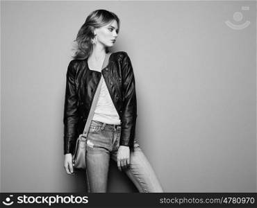 Fashion portrait of beautiful young woman with red hair. Girl in blouse and jeans. Jewelry and hairstyle. Girl with handbag. Black and White