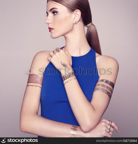 Fashion portrait of elegant woman with magnificent hair. Blonde girl. Perfect make-up. Girl in elegant dress. Flash tattoo gold