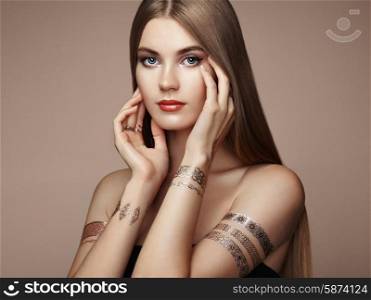 Fashion portrait of elegant woman with magnificent hair. Blonde girl. Perfect make-up. Girl in elegant dress. Flash tattoo gold