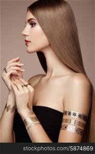 Fashion portrait of elegant woman with magnificent hair. blonde girl. Perfect make-up. Girl in elegant dress. Flash tattoo gold