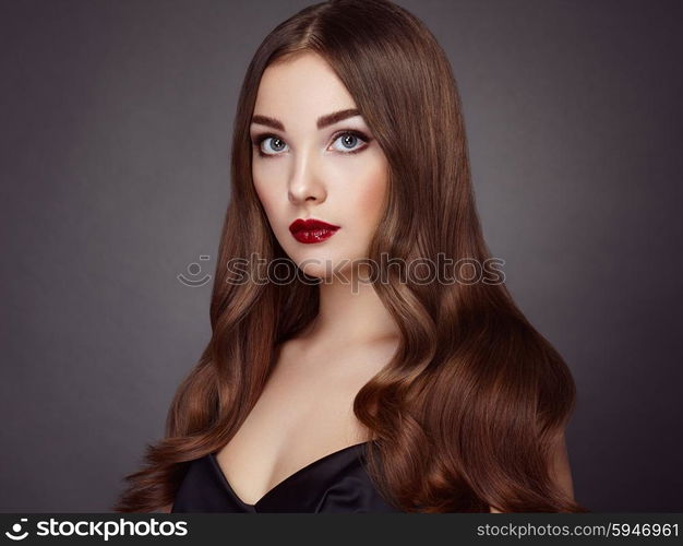 Fashion portrait of elegant woman with magnificent hair. Brunette girl. Perfect make-up. Girl in black dress. Curly hair