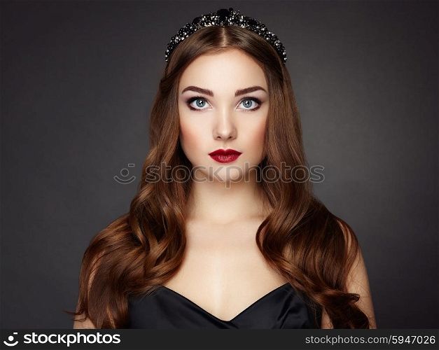 Fashion portrait of elegant woman with magnificent hair. Brunette girl. Perfect make-up. Girl in black dress. Curly hair