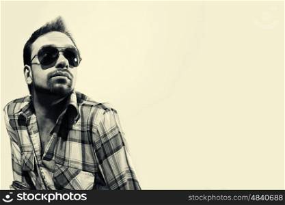 Fashion portrait of handsome young man wearing sunglasses on white background