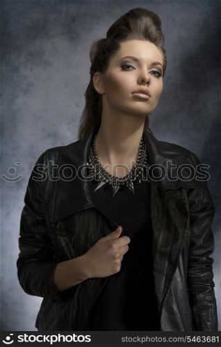 fashion portrait of pretty brunette girl with dark style and modern hair-style wearing rock necklace and leather jacket