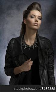 fashion portrait of pretty brunette girl with dark style and modern hair-style wearing rock necklace and leather jacket
