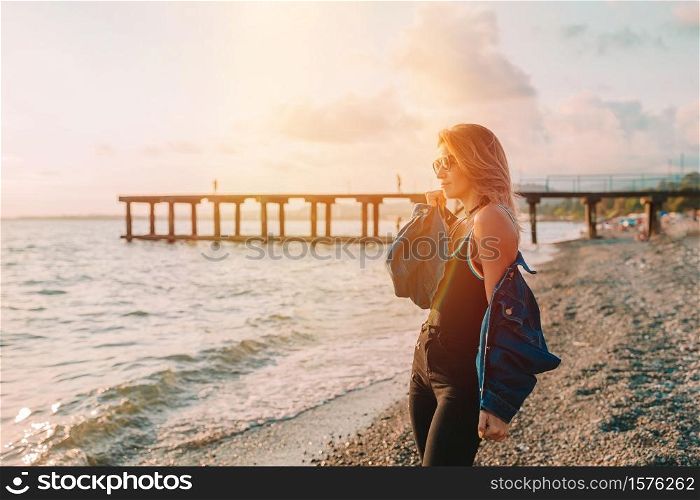 Fashion portrait of stylish woman on the beach at sunset. Outdoor fashion portrait of stylish woman on the beach.