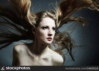 Fashion portrait of the young sexy woman with flying hair