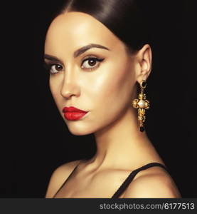 Fashion portrait of young beautiful lady with earring on black background