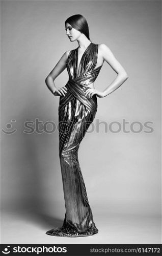 Fashion portrait of young beautiful woman in silver dress. Brunette glamour lady with perfect make up and hairstyle