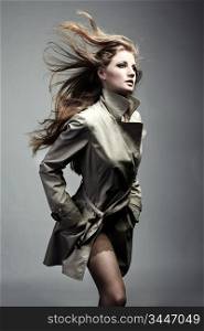 Fashion portrait of young beautiful woman in the raincoat