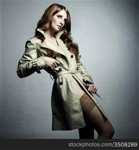 Fashion portrait of young beautiful woman in the raincoat