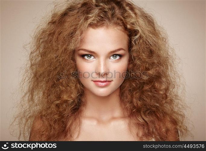 Fashion portrait of young beautiful woman with elegant hairstyle. Redhead girl with long curly hair. Perfect make-up