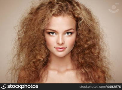 Fashion portrait of young beautiful woman with elegant hairstyle. Redhead girl with long curly hair. Perfect make-up