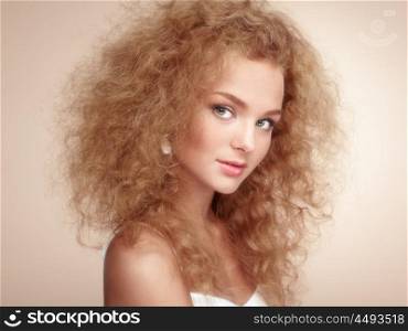 Fashion portrait of young beautiful woman with jewelry and elegant hairstyle. Redhead girl with long curly hair. Perfect make-up