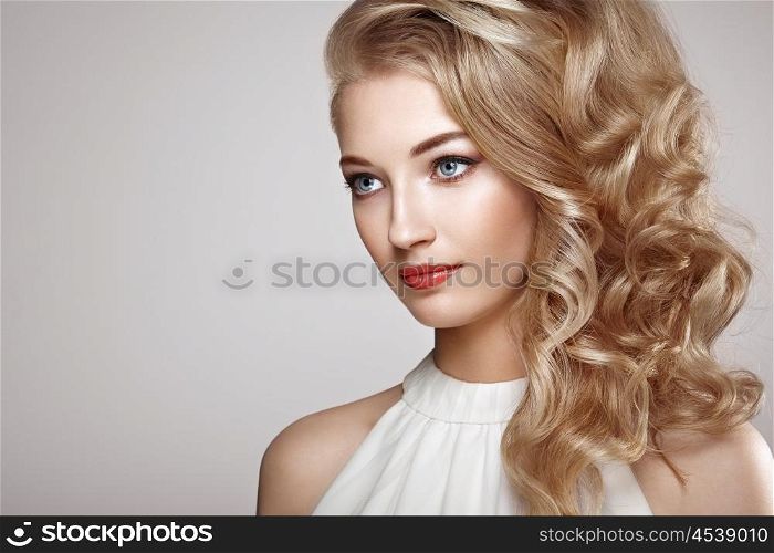 Fashion portrait of young beautiful woman with jewelry and elegant hairstyle. Blonde girl with long wavy hair. Perfect make-up. Beauty style woman with diamond accessories