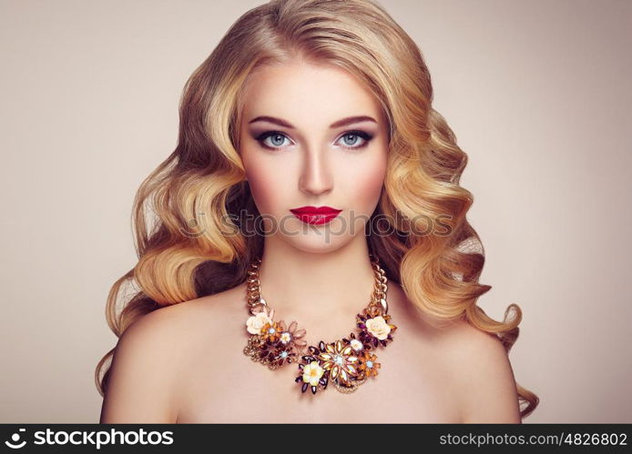 Fashion portrait of young beautiful woman with jewelry and elegant hairstyle. Blonde girl with long wavy hair. Perfect make-up. Beauty style model