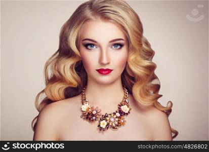 Fashion portrait of young beautiful woman with jewelry and elegant hairstyle. Blonde girl with long wavy hair. Perfect make-up. Beauty style model