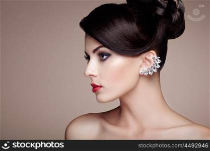 Fashion portrait of young beautiful woman with jewelry and elegant hairstyle. Brunette girl. Perfect make-up. Beauty style woman with diamond accessories