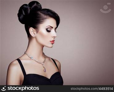 Fashion portrait of young beautiful woman with jewelry and elegant hairstyle. Brunette girl. Perfect make-up. Beauty style woman with diamond accessories