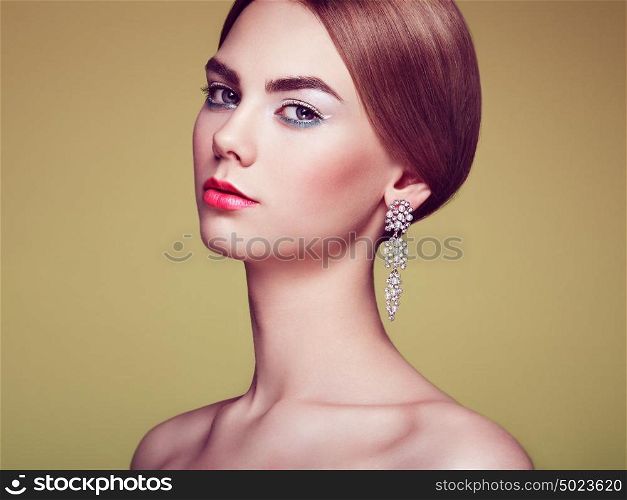Fashion portrait of young beautiful woman with jewelry. Blonde girl. Perfect make-up and hairstyle. Beauty style woman with diamond accessories. Silver earrings