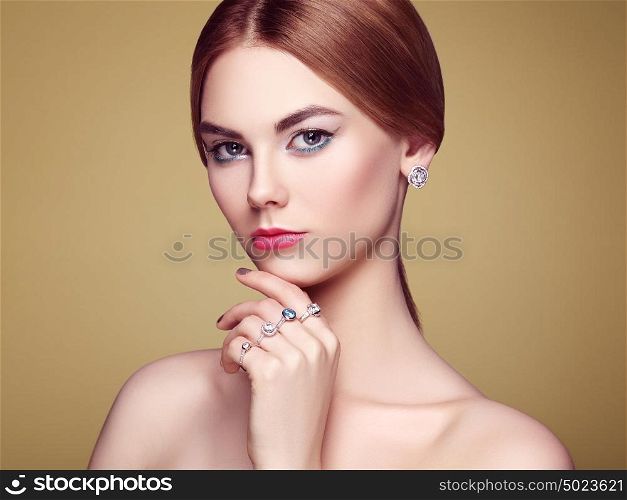 Fashion portrait of young beautiful woman with jewelry. Blonde girl. Perfect make-up and hairstyle. Beauty style woman with diamond accessories. Silver rings and earrings