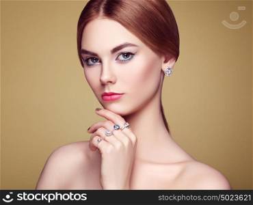 Fashion portrait of young beautiful woman with jewelry. Blonde girl. Perfect make-up and hairstyle. Beauty style woman with diamond accessories. Silver rings and earrings