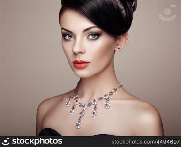 Fashion portrait of young beautiful woman with jewelry. Brunette girl. Perfect make-up. Beauty style woman with diamond accessories