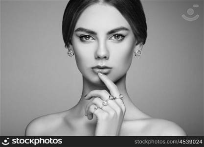 Fashion portrait of young beautiful woman with jewelry. Brunette girl. Perfect make-up. Beauty style woman with diamond accessories. Black and White