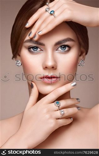 Fashion portrait of young beautiful woman with jewelry. Brunette girl. Perfect make-up. Beauty style woman with diamond accessories