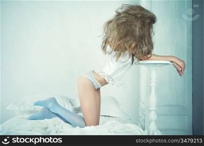Fashion portrait of young elegant woman in bed