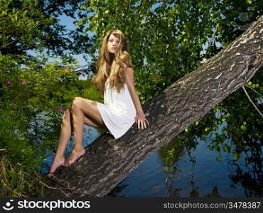 Fashion portrait of young sensual lady on tree