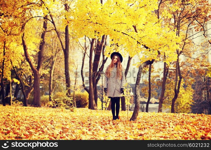 Fashion portrait outdoors young long-haired beautiful model walking in the autumn park.