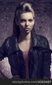 fashion portrait with dark atmosphere of pretty young girl with brown modern hair-style and casual leather jacket