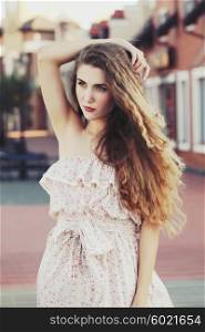 Fashion portraite of a model with long curly healthy hair, ombre