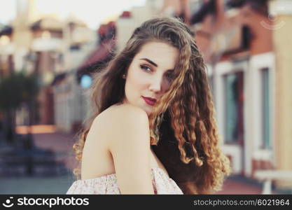 Fashion portraite of a model with long curly healthy hair, ombre