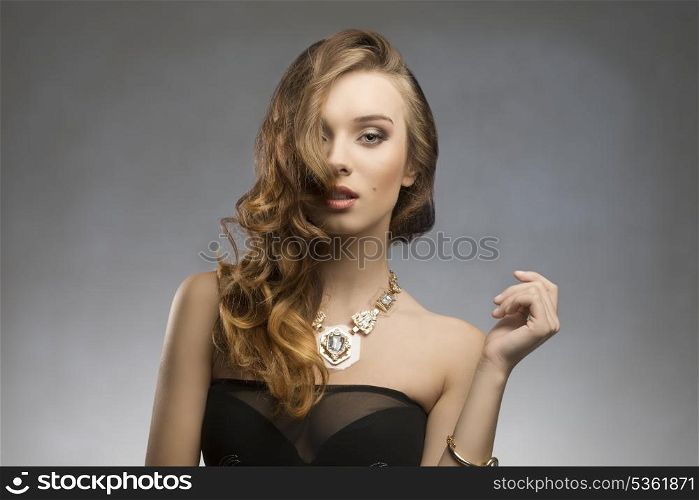 fashion pretty girl with elegant stylish, long wavy hair-style, sexy dark dress and golden necklace