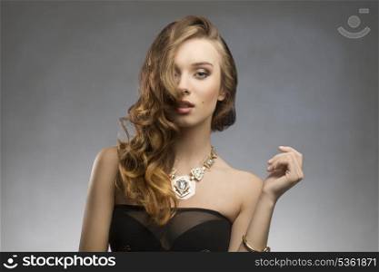 fashion pretty girl with elegant stylish, long wavy hair-style, sexy dark dress and golden necklace