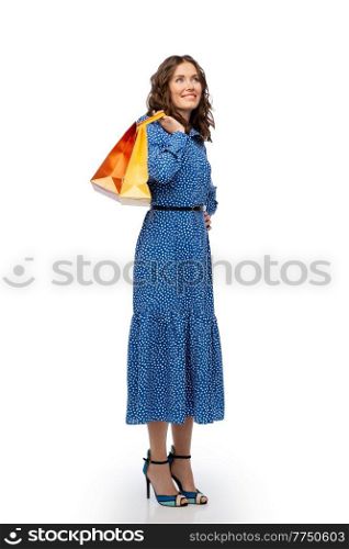 fashion, sale and people concept - happy smiling beautiful young woman posing in blue dress with shopping bags over white background. happy young woman in blue dress with shopping bags