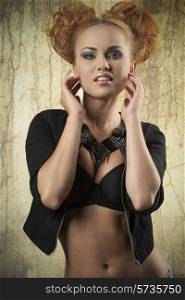 fashion shoot of cute redhead girl with bizarre pigtail hair-style, trendy necklace, black bra and jacket. Stylish make-up, cute style